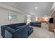 Spacious basement featuring comfortable couches and lighting and painted in neutral tones at 3919 Wentworth Dr, Durham, NC 27707