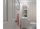 Bathroom with beige striped walls, vanity and mirror with decorative framed art on the walls at 3919 Wentworth Dr, Durham, NC 27707
