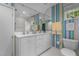 Bright bathroom featuring a double sink vanity with white cabinets and colorful striped wallpaper at 3919 Wentworth Dr, Durham, NC 27707