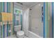 Bright bathroom featuring a toilet with shower and tub combination and colorful striped wallpaper at 3919 Wentworth Dr, Durham, NC 27707