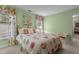 Comfortable bedroom featuring a plush floral bedspread and window with decorative curtains and green-painted walls at 3919 Wentworth Dr, Durham, NC 27707