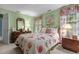 Inviting bedroom with a floral-patterned bedspread and a charming window dressed with floral curtains at 3919 Wentworth Dr, Durham, NC 27707