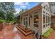 Back exterior showcasing brick and siding and a red brick patio, as well as a sunroom at 3919 Wentworth Dr, Durham, NC 27707