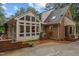 Rear exterior showcasing brick and light yellow siding, as well as a brick patio and partial driveway at 3919 Wentworth Dr, Durham, NC 27707
