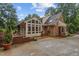Back of the house with a sunroom and brick patio surrounded by trees and other foliage at 3919 Wentworth Dr, Durham, NC 27707