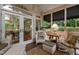 Bright sunroom featuring wicker furniture, rug, and view to the dining room through glass doors at 3919 Wentworth Dr, Durham, NC 27707