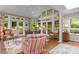 Bright sunroom with multiple windows, comfortable seating, and access to the outdoors at 3919 Wentworth Dr, Durham, NC 27707