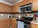 A kitchen featuring wooden cabinets, stainless steel appliances, and a tiled backsplash at 4234 Offshore Dr, Raleigh, NC 27610