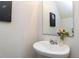 Stylish powder room with a pedestal sink, decorative mirror, and contemporary wall art, a convenient space at 4234 Offshore Dr, Raleigh, NC 27610