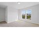 Bright bedroom features plush carpet, neutral walls, and a large window overlooking the community at 425 Edison Rail Ln, Knightdale, NC 27545