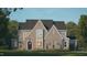 Charming two-story home featuring stone accents, arched entryway, and lush green lawn at 441 Lila Dr, Pittsboro, NC 27312