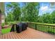 Back deck with a grill overlooking a large yard with mature trees at 498 Mountain Laurel, Chapel Hill, NC 27517