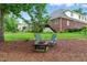 A fire pit with Adirondack chairs on a mulch bed provides a relaxing backyard focal point to this well-landscaped yard at 498 Mountain Laurel, Chapel Hill, NC 27517