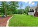 A well-maintained backyard features lush green grass, mature trees, decorative bark, and an outdoor seating area at 498 Mountain Laurel, Chapel Hill, NC 27517