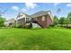 The home has a well manicured lawn with decorative bushes, a brick elevation, and a screened-in porch at 498 Mountain Laurel, Chapel Hill, NC 27517