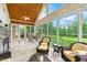 Bright sunroom with large windows, a stone fireplace, and comfortable seating, ideal for relaxation at 498 Mountain Laurel, Chapel Hill, NC 27517