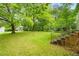 Lush backyard with mature trees provides a serene and private outdoor space at 504 Delaware Ave, Burlington, NC 27217