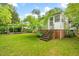 Home featuring a well-maintained backyard with lush green grass, and mature trees at 504 Delaware Ave, Burlington, NC 27217