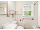 Cozy bathroom features a vanity sink, toilet, mirror, and a window letting in natural light at 504 Delaware Ave, Burlington, NC 27217