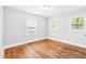 Bright bedroom with hardwood floors and three large windows allowing ample natural light at 504 Delaware Ave, Burlington, NC 27217