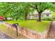 Well-maintained front yard featuring lush green grass, mature trees, and a charming brick mailbox at 504 Delaware Ave, Burlington, NC 27217