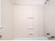 Clean shower features a white surround with built-in shelving for toiletries and essential items at 504 Delaware Ave, Burlington, NC 27217