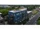 Aerial view of a contemporary blue apartment building surrounded by lush greenery and street views at 515 N Mangum St # 41, Durham, NC 27701