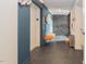 Hallway with slate tile, a gray accent wall, an orange bench, and stainless steel trash can at 515 N Mangum St # 41, Durham, NC 27701