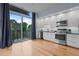 Bright kitchen with white cabinets, stainless steel appliances, and a large sliding glass door to a balcony at 515 N Mangum St # 41, Durham, NC 27701