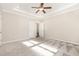 Bright bedroom with tray ceilings, carpeted floors, ceiling fan, and neutral paint at 57 S Shreve Dr, Wendell, NC 27591