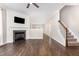 Open-concept living room with hardwood floors, a fireplace, and staircase access at 57 S Shreve Dr, Wendell, NC 27591
