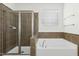 Beautiful bathroom features a glass shower with tile surround, white garden tub, and large window at 59 Tobacco Farm Way, Chapel Hill, NC 27516