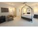 A stylish bedroom featuring a canopy bed, elegant sconces, and a comfortable seating area at 59 Tobacco Farm Way, Chapel Hill, NC 27516