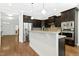 Contemporary kitchen featuring dark wood cabinets, stainless appliances, and a breakfast bar at 59 Tobacco Farm Way, Chapel Hill, NC 27516