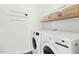Cozy laundry room with new washer and dryer, decorative wall hangings and overhead shelving at 59 Tobacco Farm Way, Chapel Hill, NC 27516