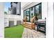 A cozy, fenced backyard with a small lawn, stone patio, and outdoor grill at 606 Velma Hopkins Ln, Raleigh, NC 27603