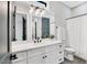 Modern bathroom with white cabinets, quartz countertops, and a large mirror at 606 Velma Hopkins Ln, Raleigh, NC 27603