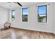 Well-lit bedroom featuring hardwood floors and three large windows overlooking the neighborhood at 606 Velma Hopkins Ln, Raleigh, NC 27603