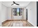 Bright bedroom featuring hardwood floors, a ceiling fan, and a window overlooking the neighborhood at 606 Velma Hopkins Ln, Raleigh, NC 27603