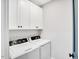Functional laundry room with a side-by-side washer and dryer and overhead storage at 606 Velma Hopkins Ln, Raleigh, NC 27603