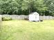 Large backyard with lush green grass, a storage shed, and a wooden fence, offering ample space for recreation and storage at 609 Redford Place Dr, Rolesville, NC 27571