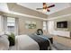 This bedroom boasts a tray ceiling, ceiling fan, and a soothing neutral color palette at 609 Redford Place Dr, Rolesville, NC 27571