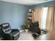 Inviting bedroom with blue walls, comfortable seating, bookcase, and natural light from the window at 609 Redford Place Dr, Rolesville, NC 27571