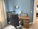 Comfortable bedroom with blue walls, office desk, and rolling chair, providing a functional and relaxing space at 609 Redford Place Dr, Rolesville, NC 27571