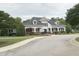 Charming clubhouse with a covered porch, white pillars, dormer windows, and meticulous landscaping, creating a welcoming atmosphere at 609 Redford Place Dr, Rolesville, NC 27571