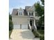Traditional two-story home featuring a two-car garage, light siding, and manicured landscaping at 609 Redford Place Dr, Rolesville, NC 27571