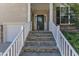 Inviting front porch featuring stone steps, white railings, and a stylish front door, creating a warm welcome to the home at 609 Redford Place Dr, Rolesville, NC 27571
