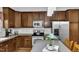 Well-lit kitchen featuring wood cabinets, stainless steel appliances and gray countertops at 609 Redford Place Dr, Rolesville, NC 27571