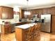 Spacious kitchen featuring wooden cabinets, stainless steel appliances, and a large center island with seating at 609 Redford Place Dr, Rolesville, NC 27571