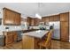 Kitchen with wood cabinets, stainless steel appliances, island, and hardwood floors at 609 Redford Place Dr, Rolesville, NC 27571